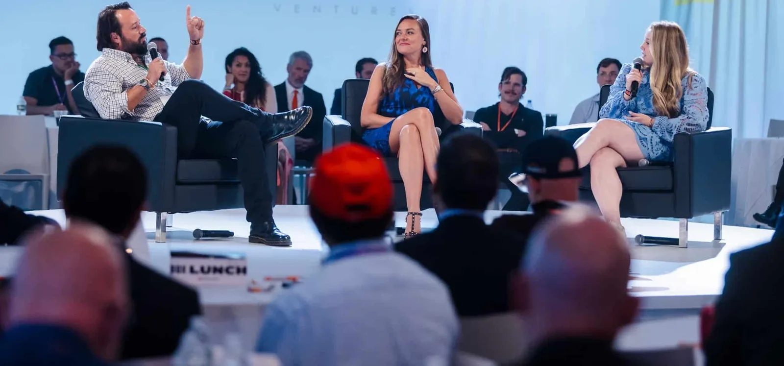A panel discussion on a conference stage in front of an audience